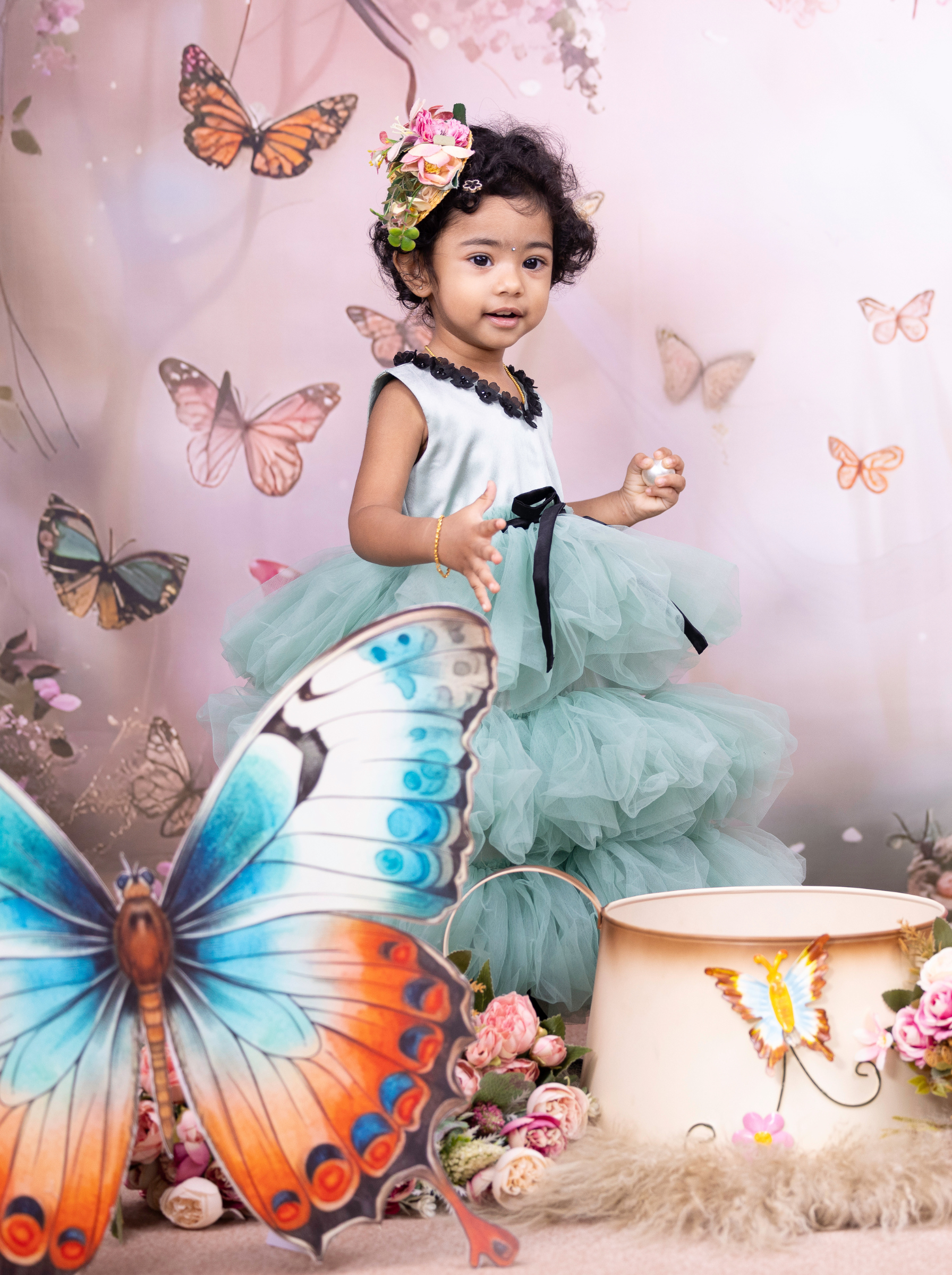 Little girl wearing a eucalyptus green party dress with layered tulle skirt