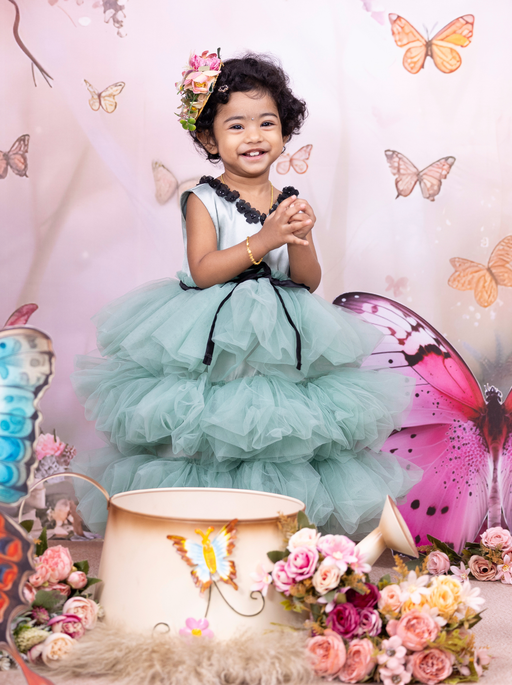 Side view of little girl wearing a eucalyptus green tiered tulle dress