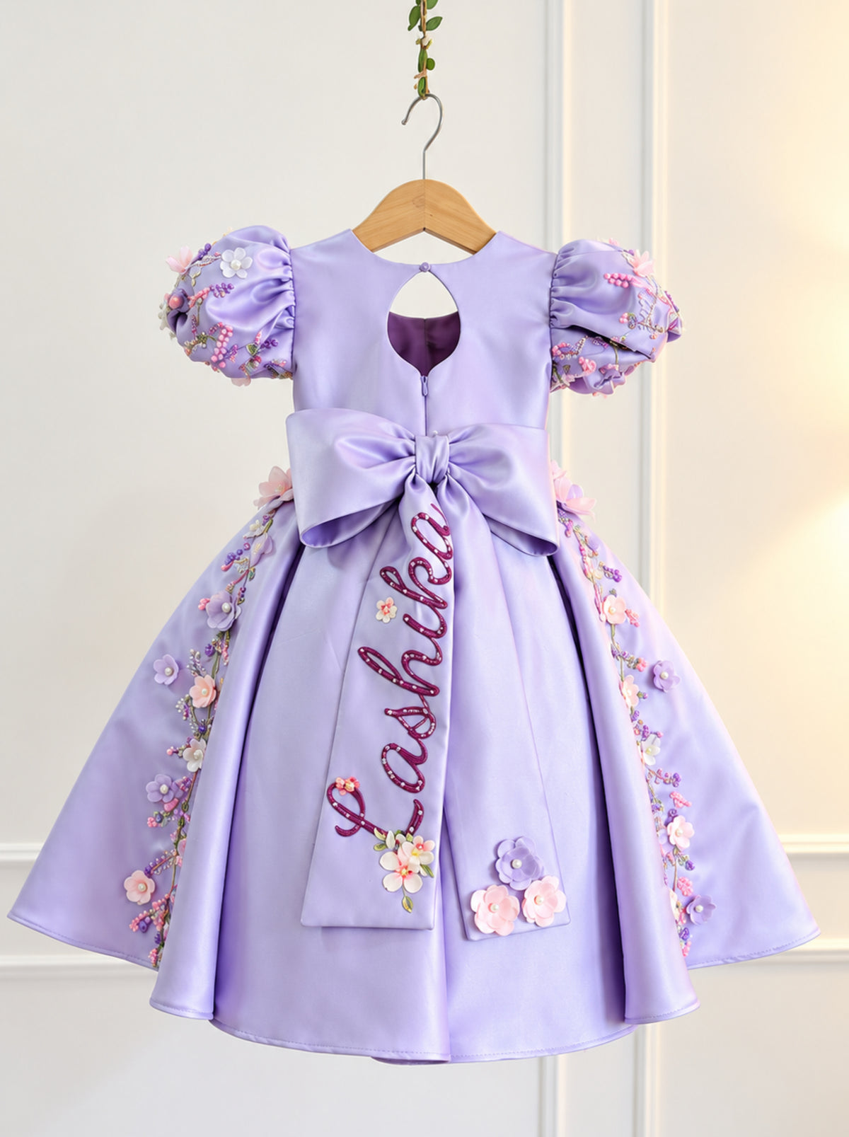Back view of lavender girls couture dress with large bow and personalized detail
