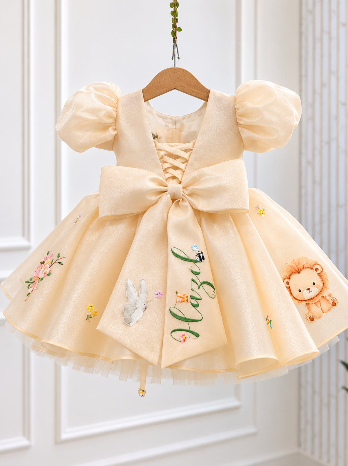 Back view of cream personalized safari birthday dress with oversized bow and name detail