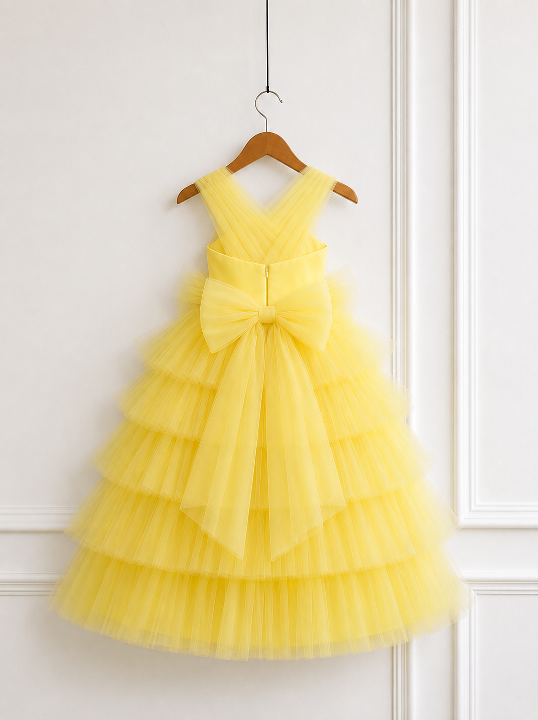Pleated V-back detail on a yellow tulle party dress for girls.