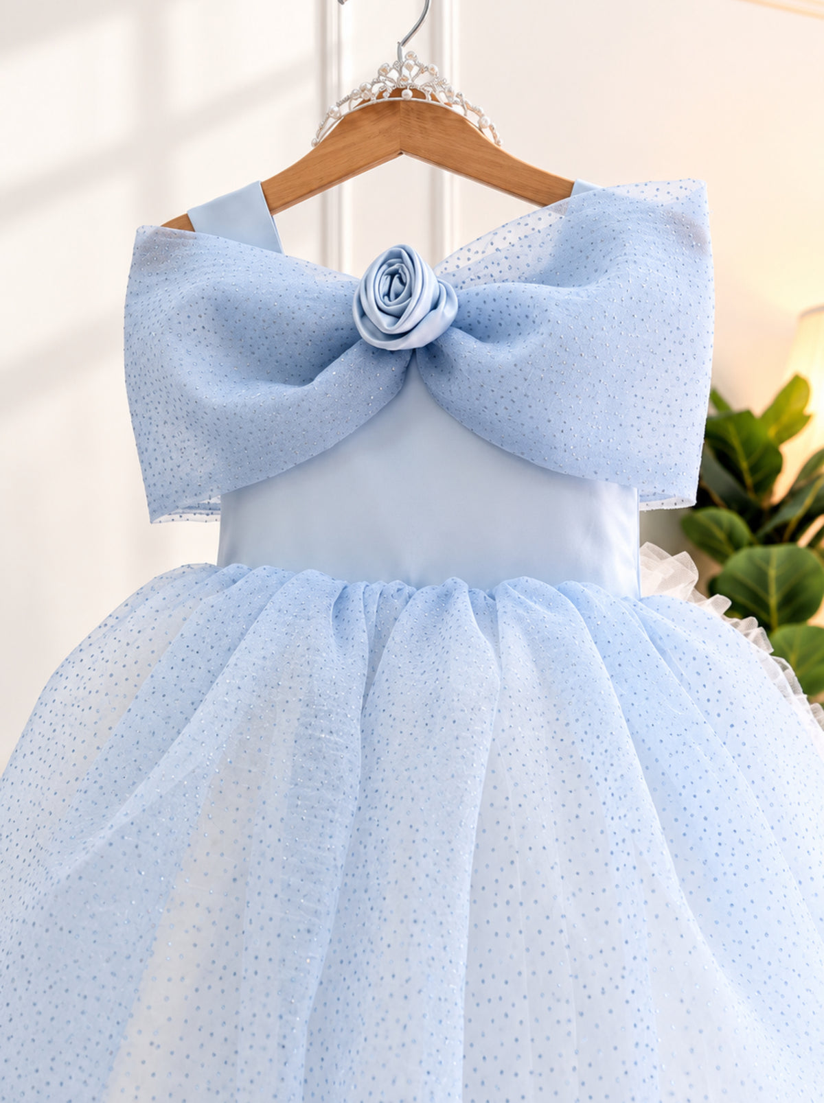 Close-up of Elsa inspired girls princess dress showing shimmering blue net, statement bow and floral hairband detail