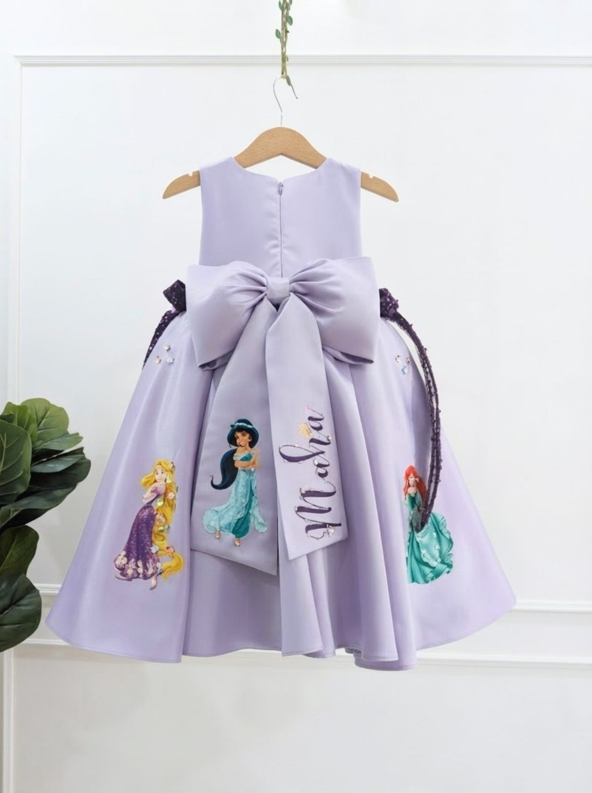 Back view of lavender princess inspired girls dress with large satin bow and personalized name detail