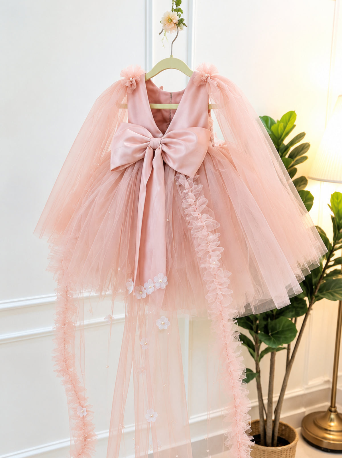 Back view of pastel pink 3D floral fairy dress for girls with oversized bow and sheer tulle trails