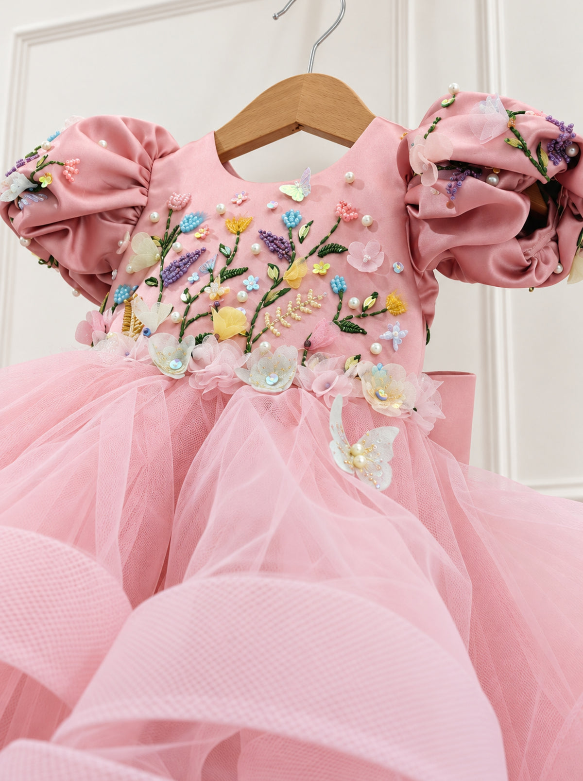 Detailed view of pink satin bodice with hand embroidery and handmade floral embellishments
